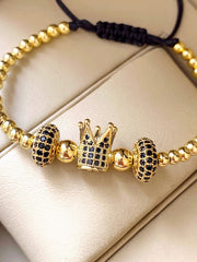 Μοντέλο βραχιόλι με χρυσές χάντρες και στέμμα με μαύρα βότσαλα