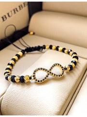 Bratara onix fatetat pe globuri si inox aurit, model infinit